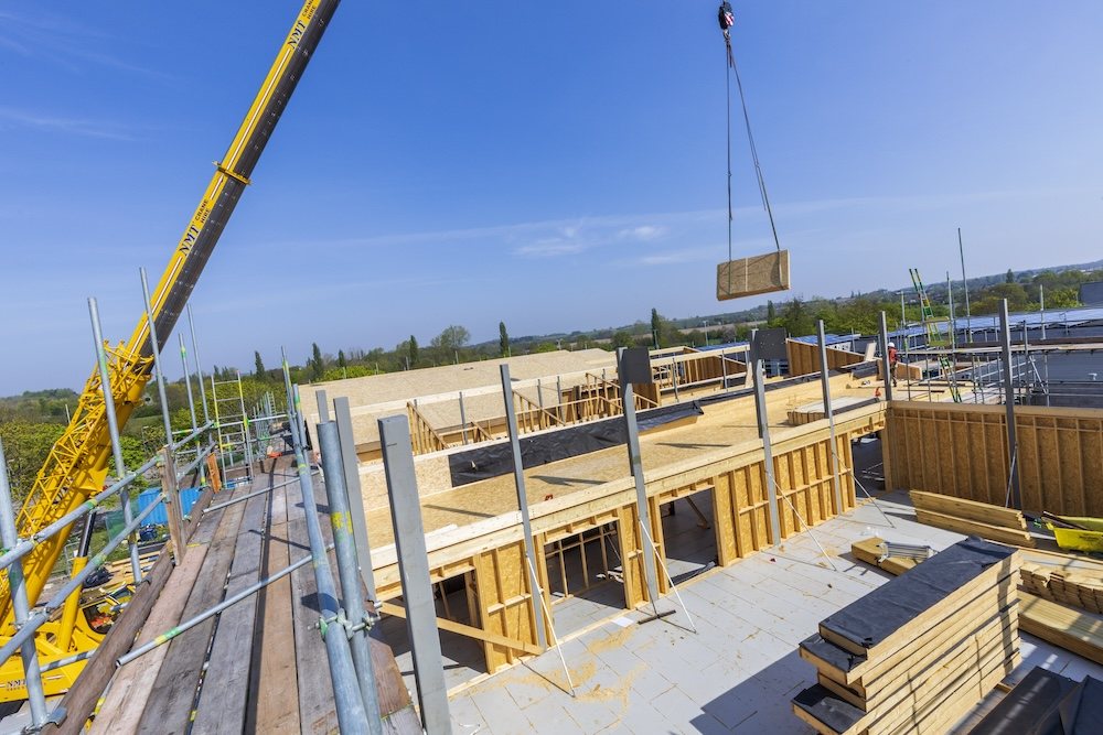Crane lifting a structural panel into position