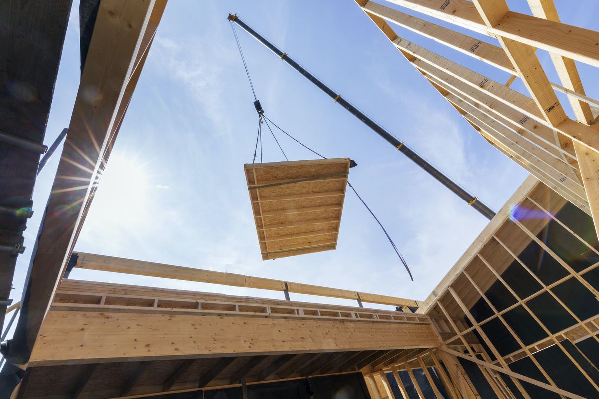 Crane lifting offsite panels into place on a live school site